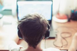 child using computer and wearing headphones