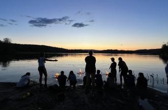 campers and staff around fires at the lake