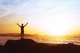 stock photo person watching sunrise over ocean