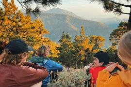 Group of campers looking at autumn mountain view