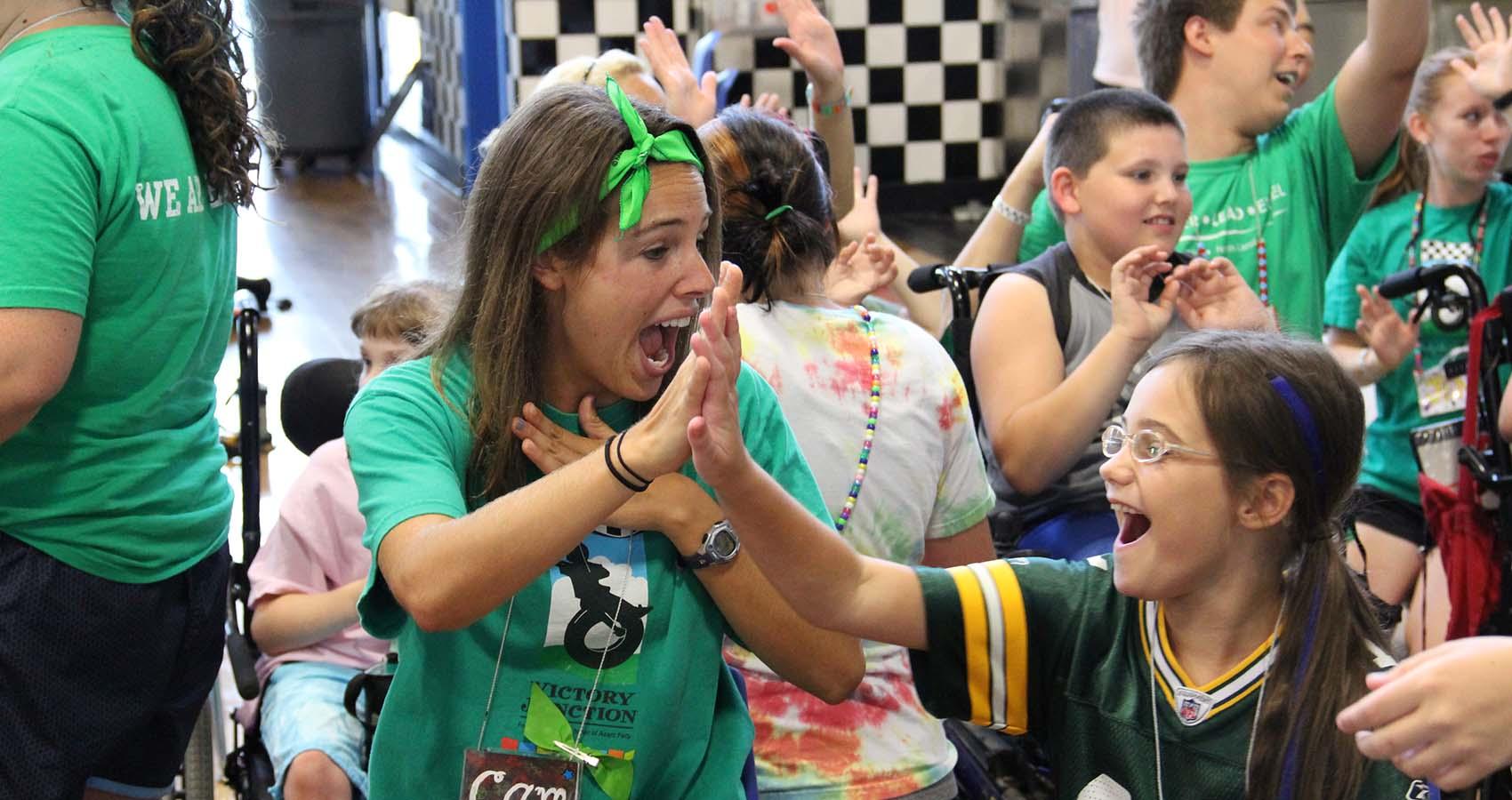 staff member high-fiving a camper