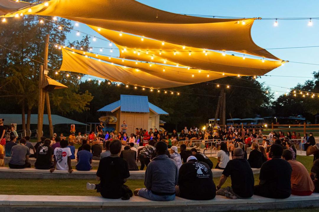 Campers sitting under canopy pavilion 