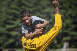 Counselor holding camper with his fist in the air