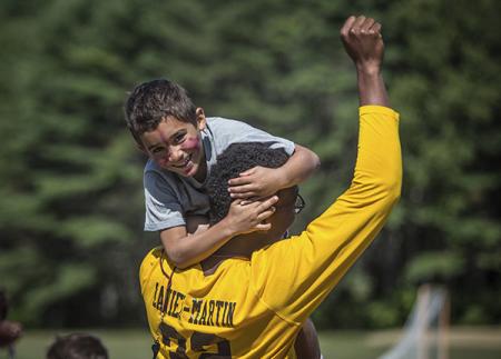 Counselor holding camper with his fist in the air