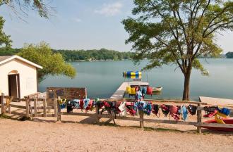 stock photo of lifejackets hanging on fence by lake