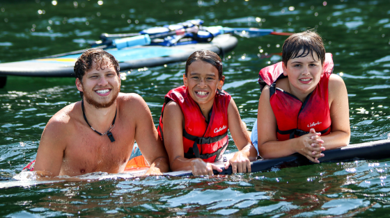 Counselor with campers in water