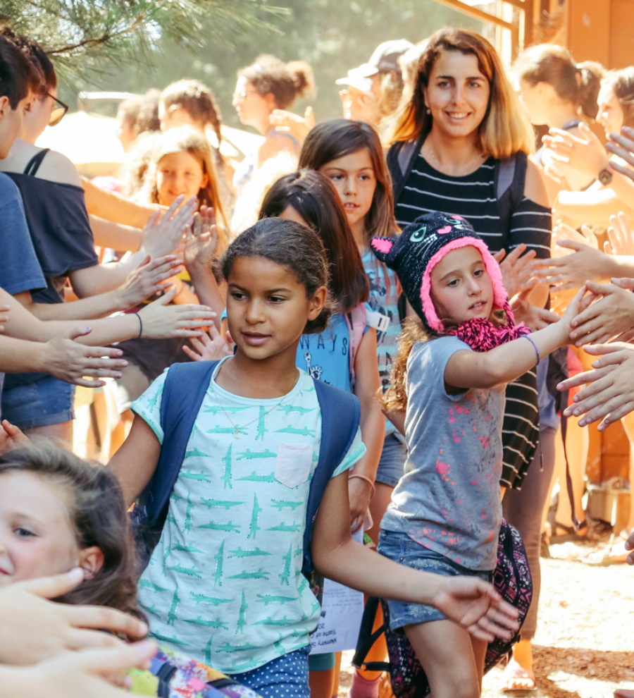 Line of campers high fiving through tunnel of staff