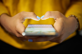 Woman typing phone message at night