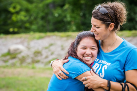 Camp director and former camper hugging